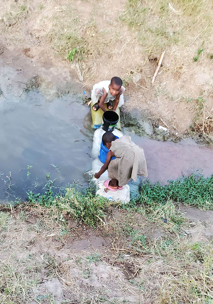 Children collecting water from a polluted water source