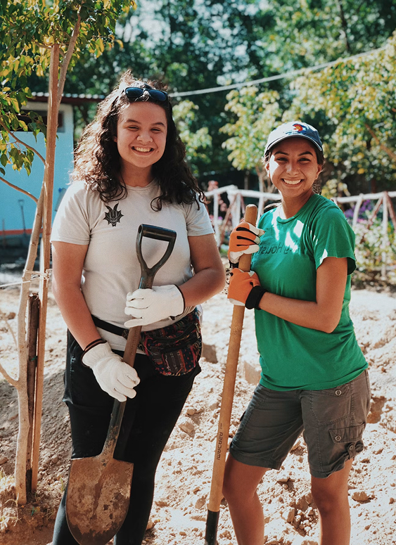 Two volunteers planting trees outdoors