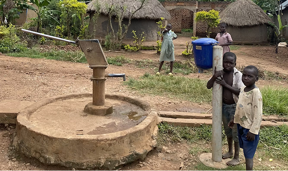 Children collecting water from a hand pump in a rural community